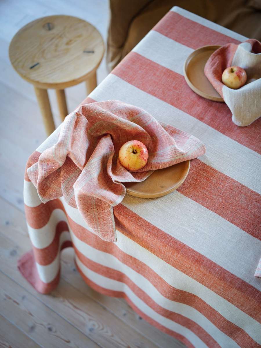 Servilletas de lino a rayas con manzanas sobre un mantel Venice Brick