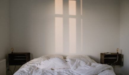 Mesita de noche elegante junto a una cama de lino