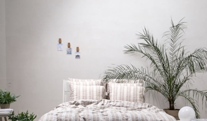 Habitación de invitados con ropa de cama de lino a rayas y plantas