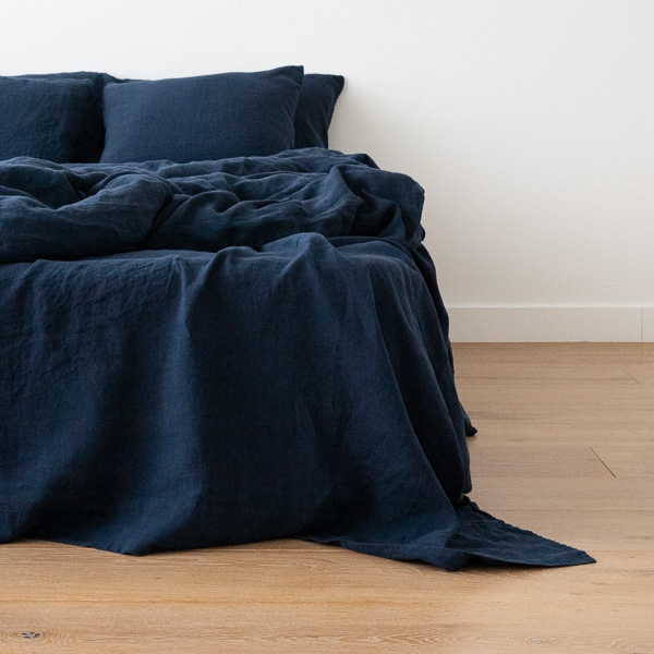 Ropa de cama de lino lavado azul marino sobre una cama
