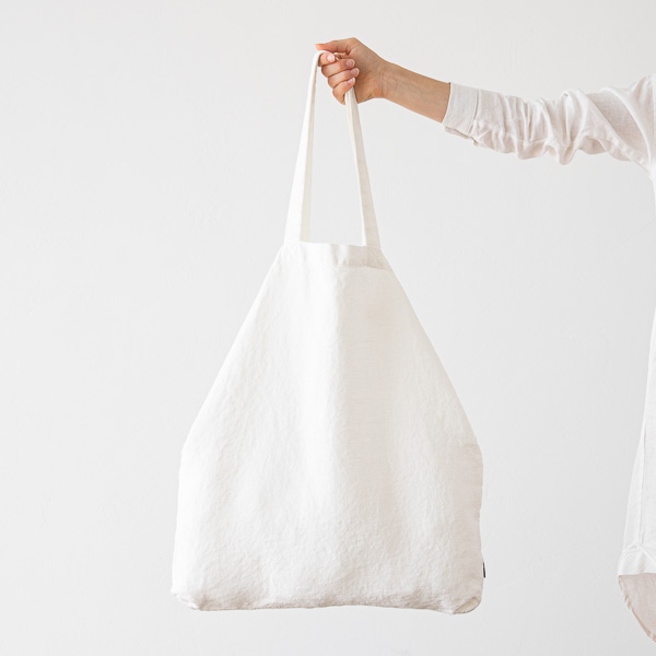 Bolsa de compras de lino Terra Off White sostenida con la mano
