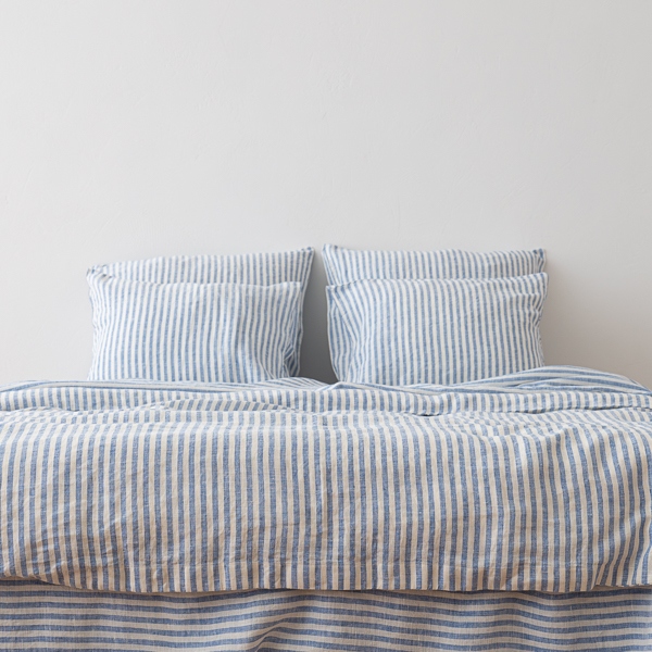 Ropa de cama de lino Blue Ticking Stripe sobre una cama, vista frontal