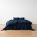 Vista amplia de una cama vestida con lino lavado azul marino