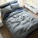 Ropa de cama de lino gris sobre una sábana encimera azul marino